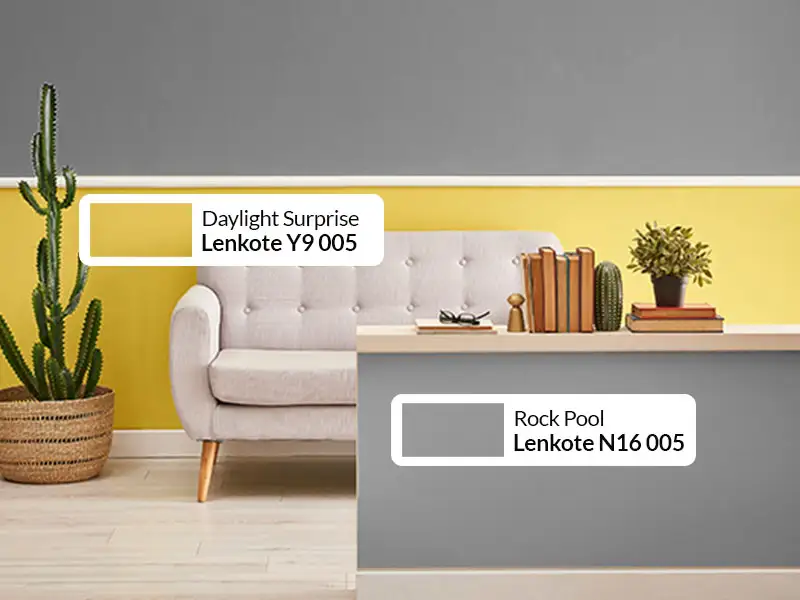 Dinding rumah dengan warna mustard dan abu-abu gelap yang bold dan modern.